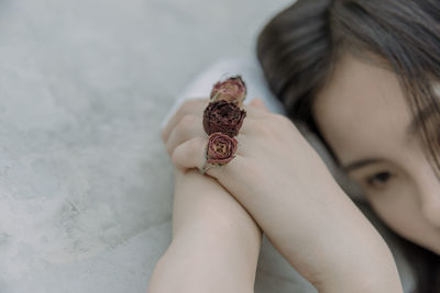 Cropped image of young woman wearing rose shape rings on retaining wall