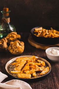 Pieces of celery root fried with paprika on a plate on the table vertical view