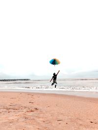 Man surfing on beach against sky