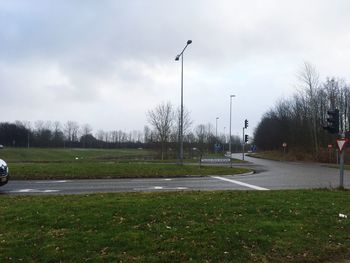 Road by trees against sky