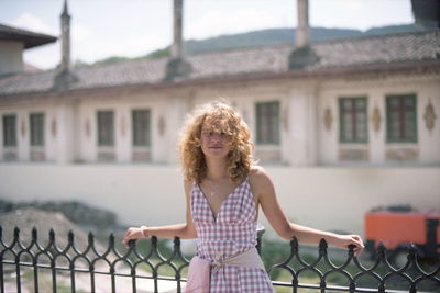 Portrait of woman standing against building