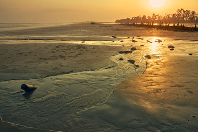 Scenic view of beach against sky during sunset