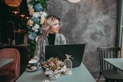 Woman sitting on table in restaurant