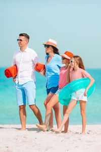 People on beach umbrella against sky