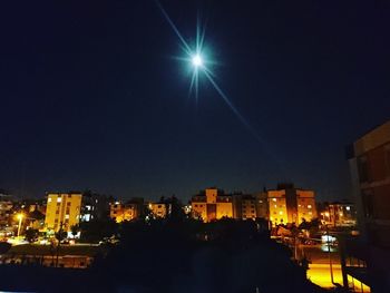 Illuminated city against sky at night