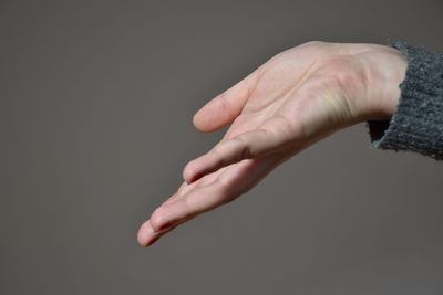 Close-up of person hand against gray background