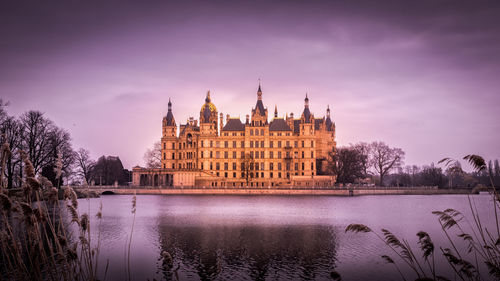 View of building by river against sky