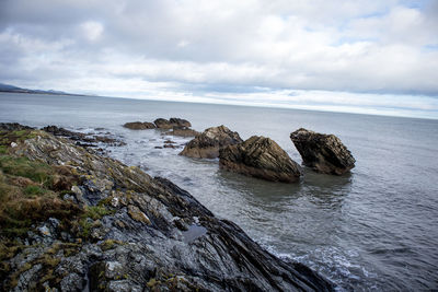 Scenic view of rocks in sea against sky