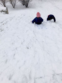 Rear view of people on snow covered field