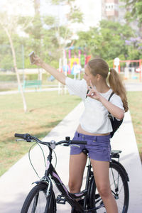 Full length of woman with bicycle in park