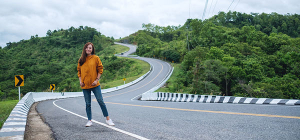 Rear view of woman walking on road