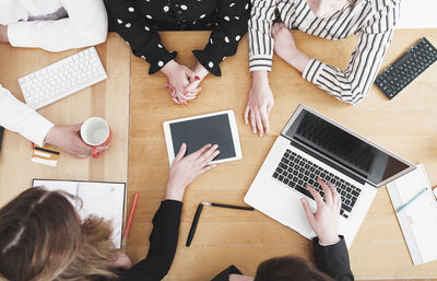 High angle view of people using laptop on table