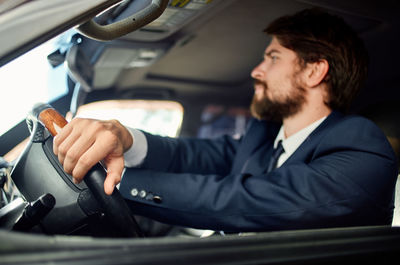 Side view of businessman using mobile phone while sitting in car