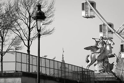 Statue in city against sky