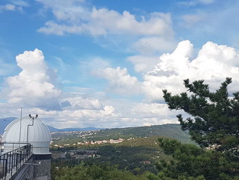 Scenic view of trees and buildings against sky
