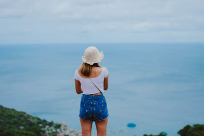 Rear view of woman looking at sea against sky