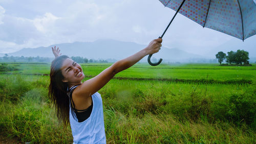 Full length of man holding umbrella on field