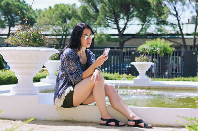 Young happy business woman relaxing in city, park. using phone. selfie. technology. summer vacation