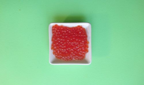 Directly above shot of strawberries in plate against green background