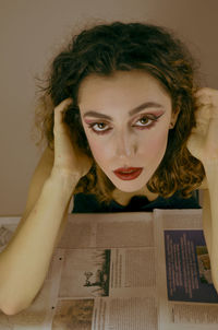 Portrait of young woman with book on table