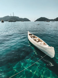 Sailboats moored on sea against clear sky