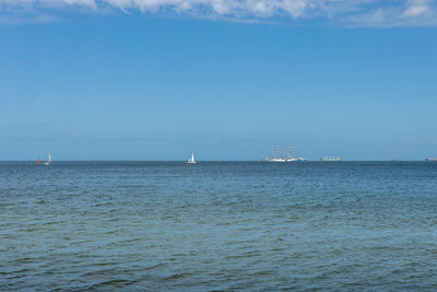 Sailboats in sea against sky