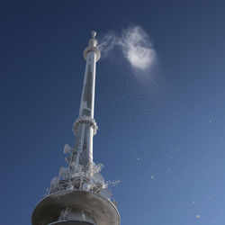 Low angle view of clock tower against blue sky