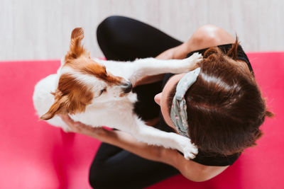 High angle view of woman with dog at home