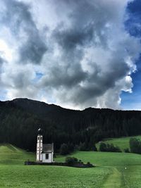 Scenic view of field and buildings against sky