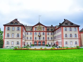 Building by lawn against sky