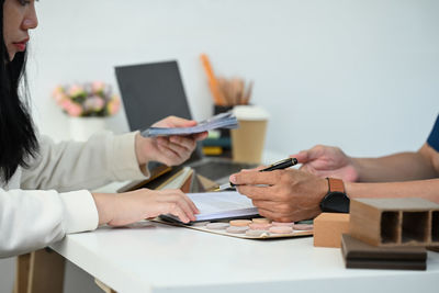 Midsection of woman using mobile phone on table