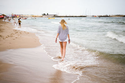 Rear view of woman standing on beach