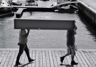 Low section of man walking on pier