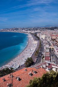 High angle view of buildings and sea against blue sky