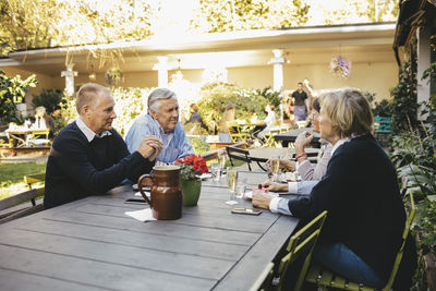 Happy senior couples discussing at outdoor restaurant