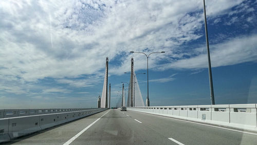 Road by bridge against sky