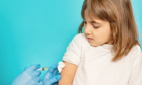 Girl taking vaccination from doctor