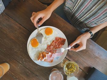 Midsection of woman having food on table