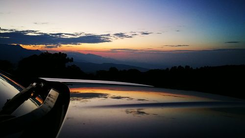 Car on road against sky during sunset