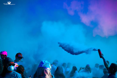 Crowd at music concert against blue sky