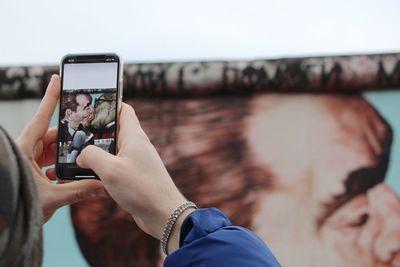 Midsection of woman photographing with mobile phone