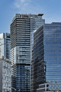 Low angle view of modern buildings against blue sky