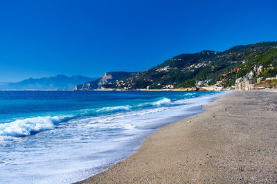 Scenic view of beach against blue sky