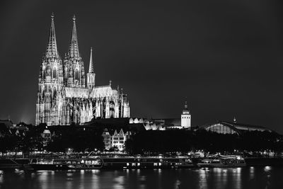 Illuminated buildings in city against sky at night