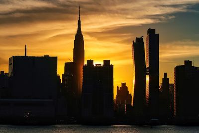 Silhouette buildings against sky during sunset