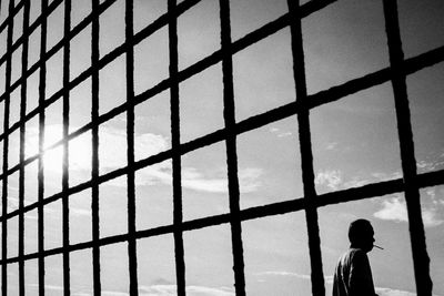 Silhouette man standing against window