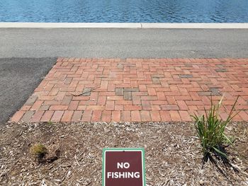 High angle view of text on cobblestone street by sea