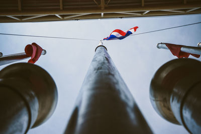 Low angle view of flags hanging against sky