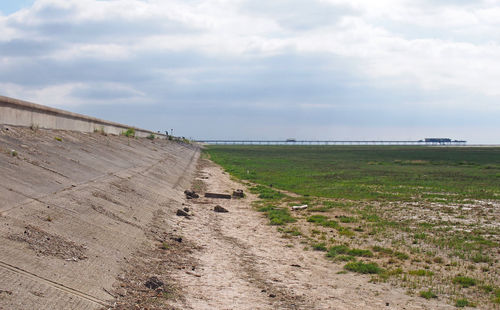 Footpath on field against sky