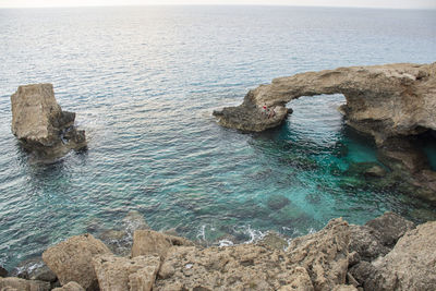 Rock formation in sea against sky